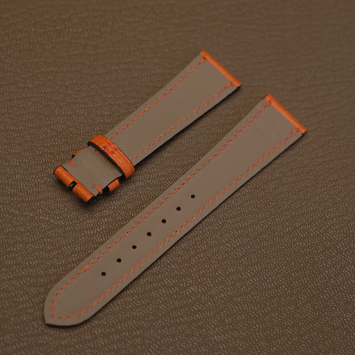 Light grey waterproof Haas Zermatt lining on custom goatskin watch strap with orange perimeter stitching