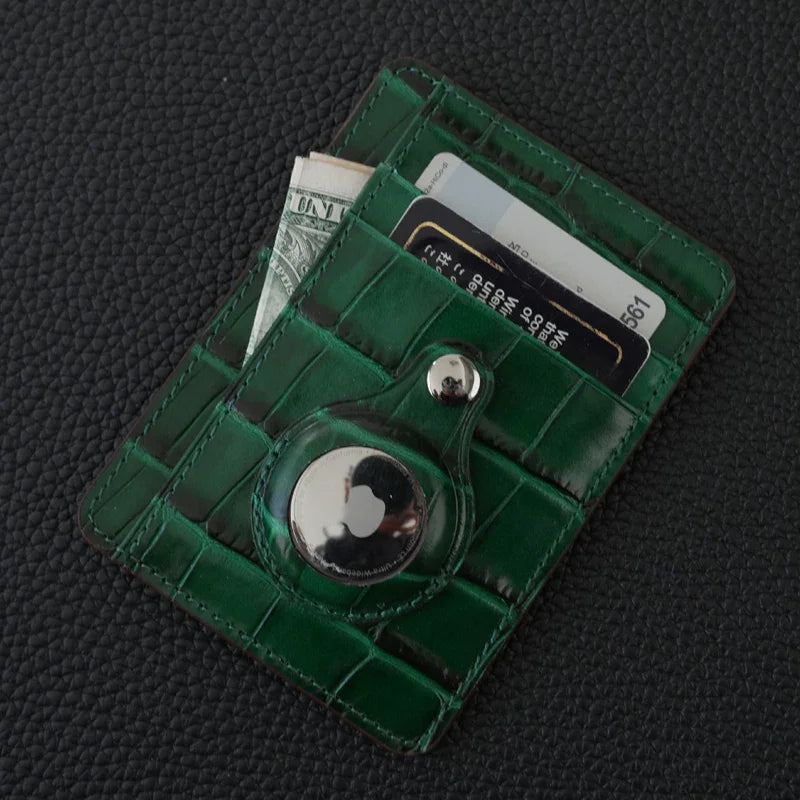 Green card wallet embossed crocodile pattern and a button on a dark textured background