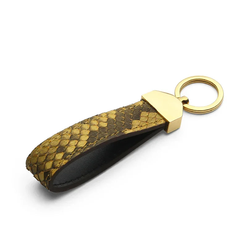 Keychain with yellow snake skin and gold accent on a white background