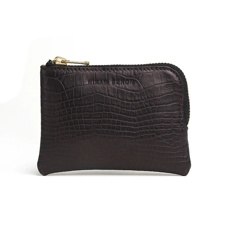 Black leather aligator pattern coin pouch with gold zipper on a white background