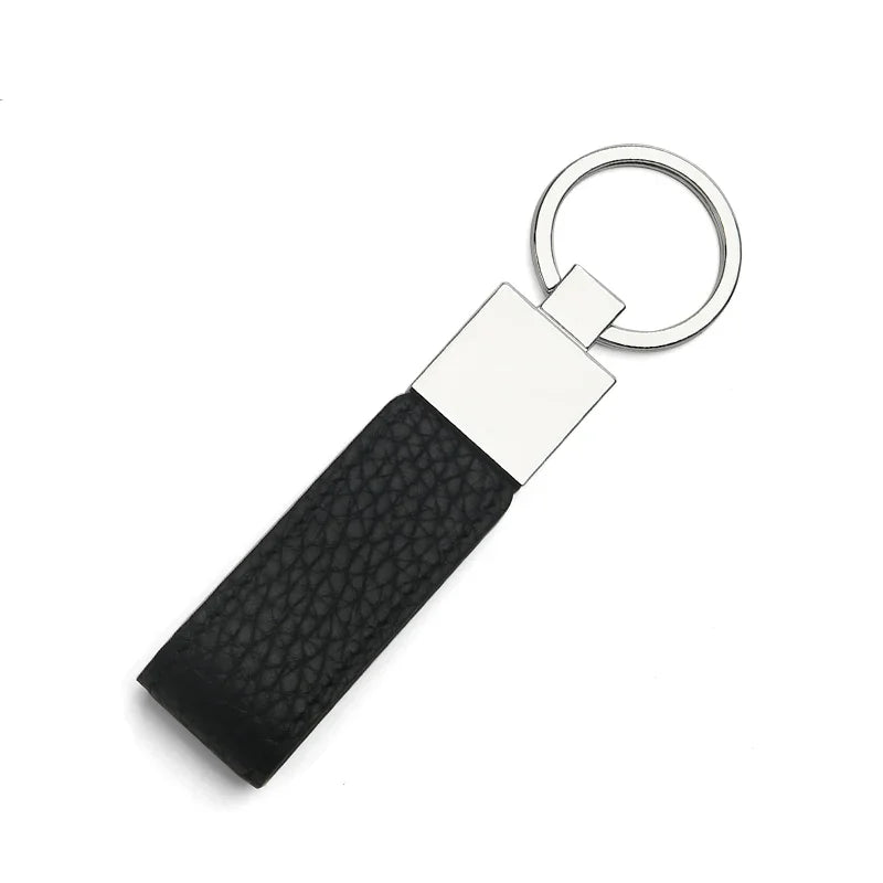Green leather key fob with a metal tag on a white background