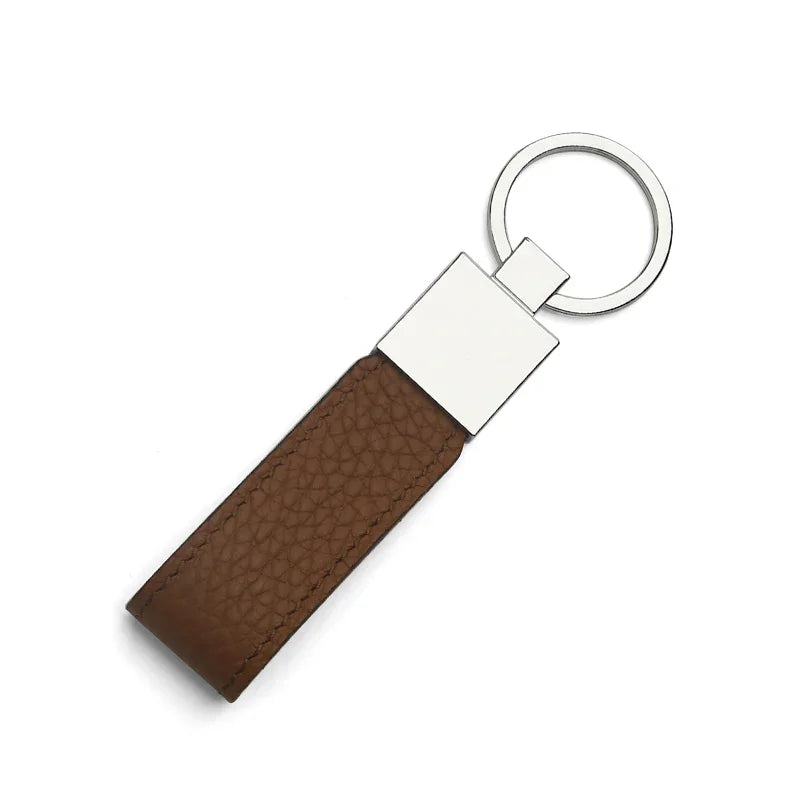 Brown leather key fob with silver metal tag on a white background
