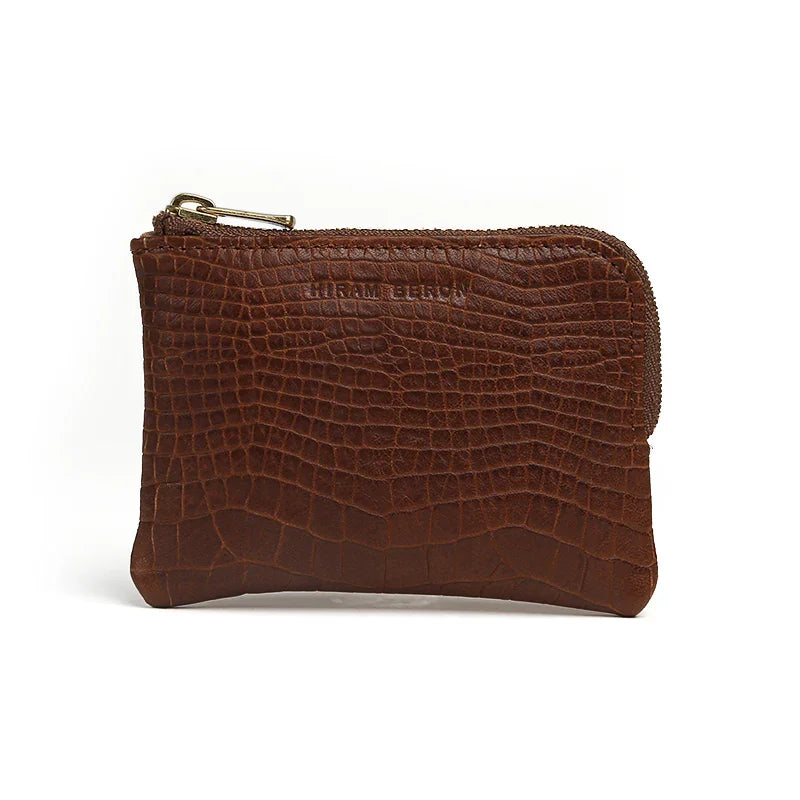 Brown aligator pattern leather coin pouch with a gold zipper on a white background