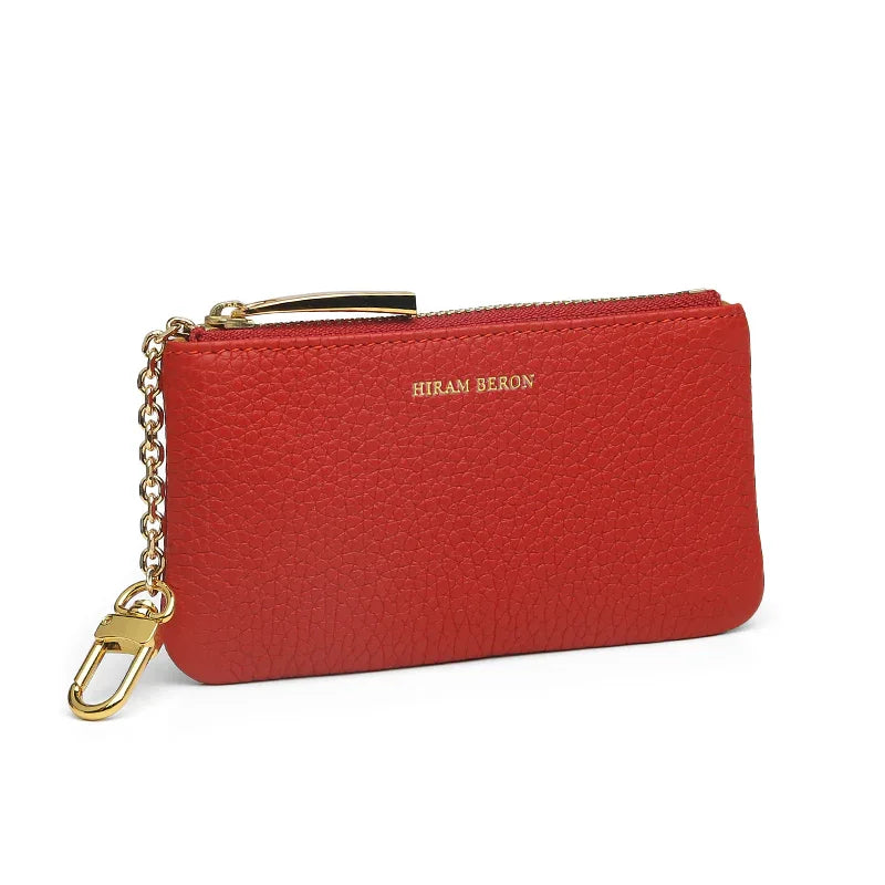 Red leather key case with gold chain and clasp on a white background