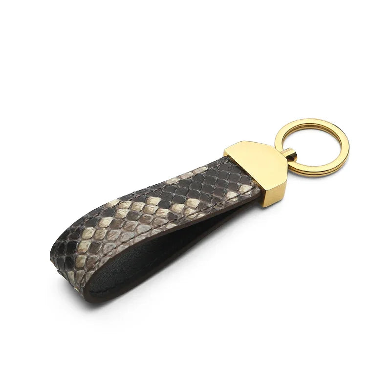 Keychain with snake skin and gold accent on a white background