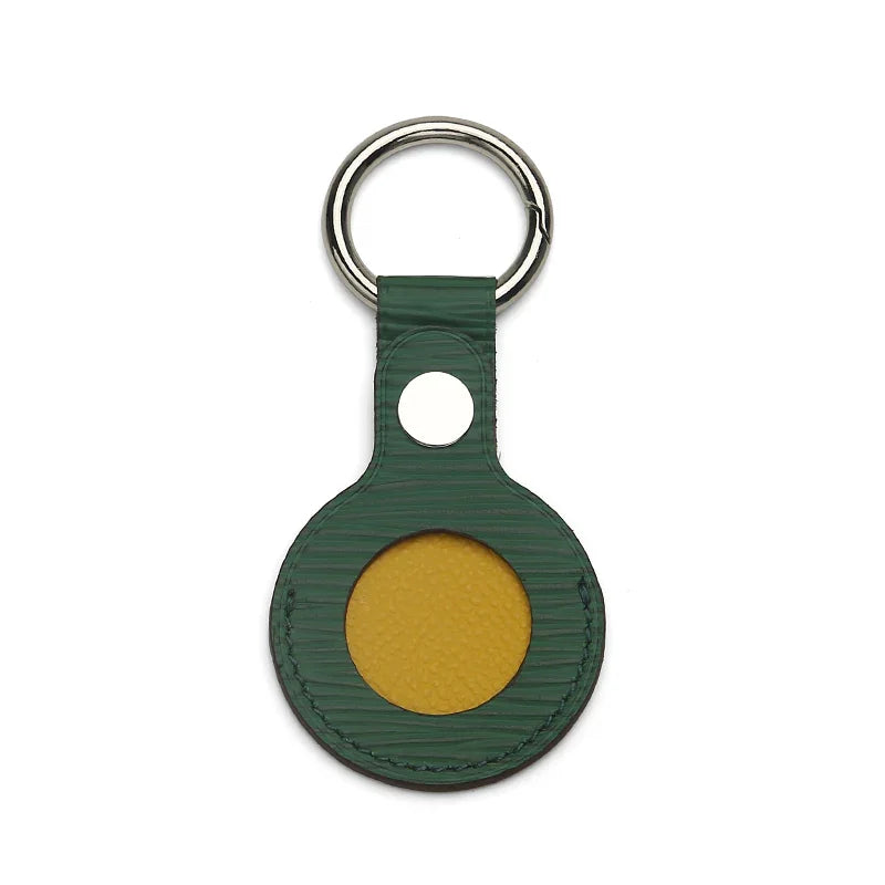 Green leather keychain with yellow accent circle and silver ring, luxury accessory