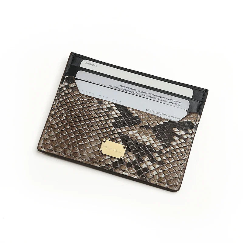 Snake skin card holder with gold metal logo on a white background