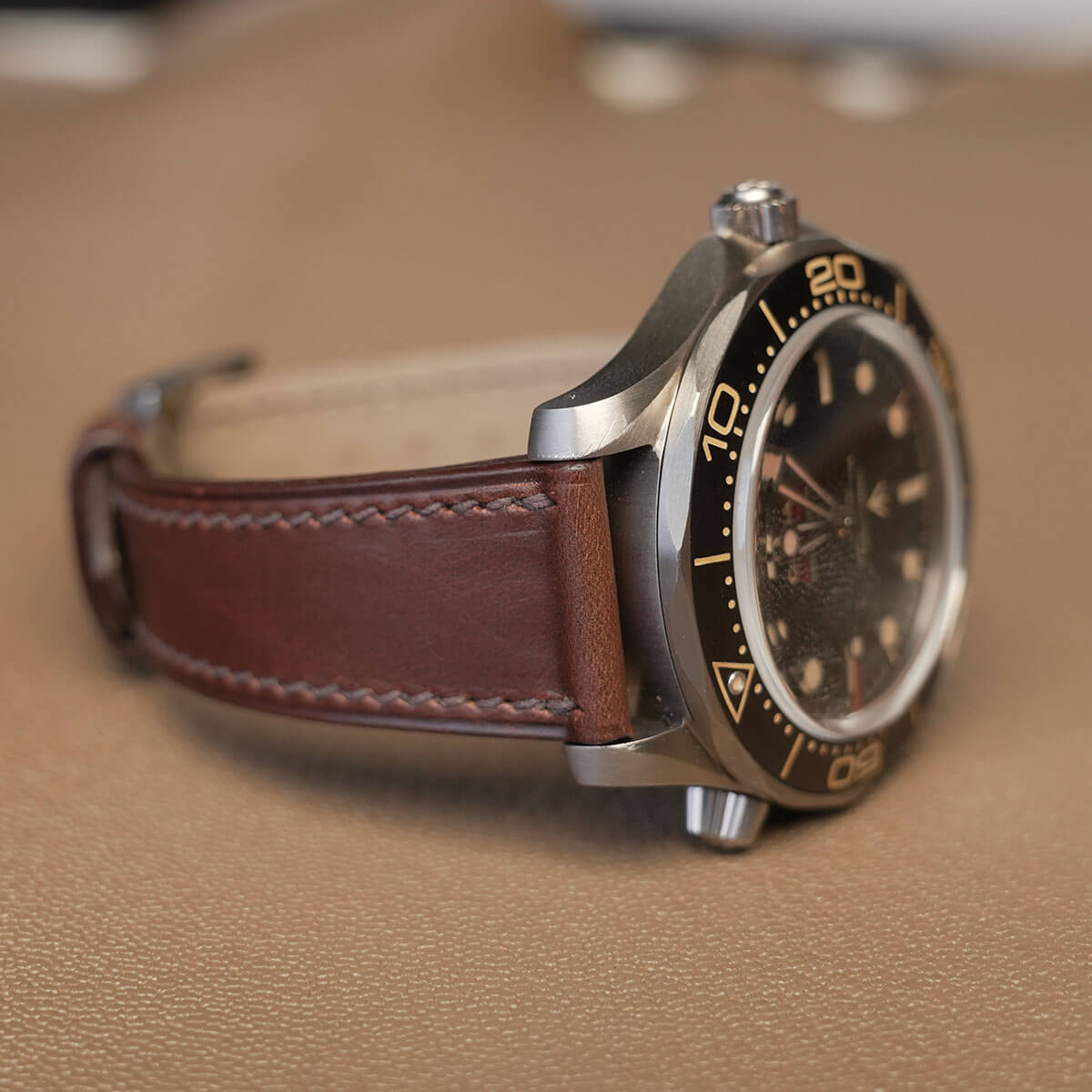 Side profile of 1.8mm slim flat brown Horween leather watch band fitted on sports watch case