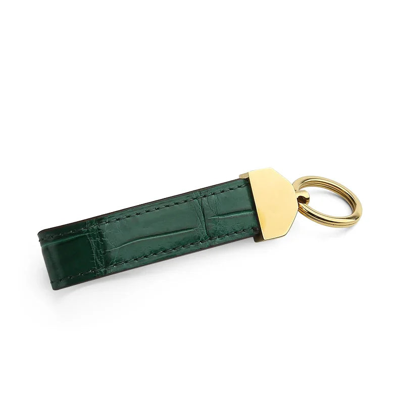 Green crocodile skin key fob with a gold ring tag on a white background