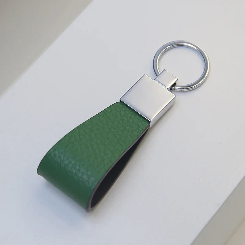 Green leather keychain with silver ring on a white surface
