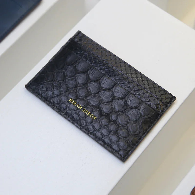 Black python skin wallet case with 'Hiram Beron' old stamping on a white surface
