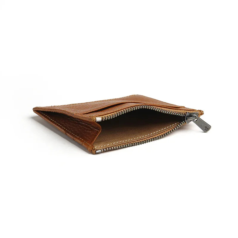 close-up of the top zipper pocket for the brown wallet with a white background