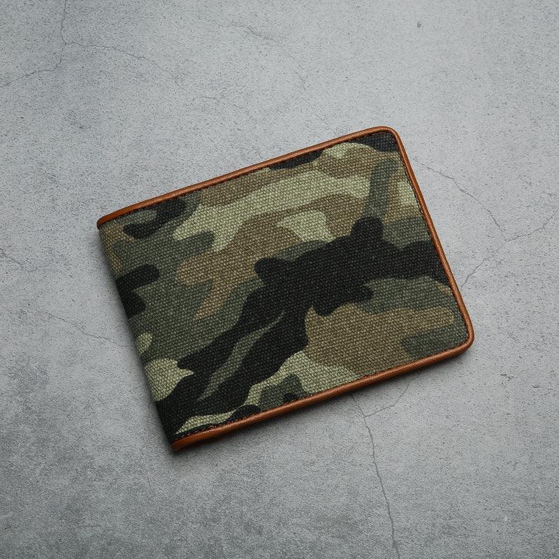 Camouflage canvas wallet with brown trim on a gray concrete surface