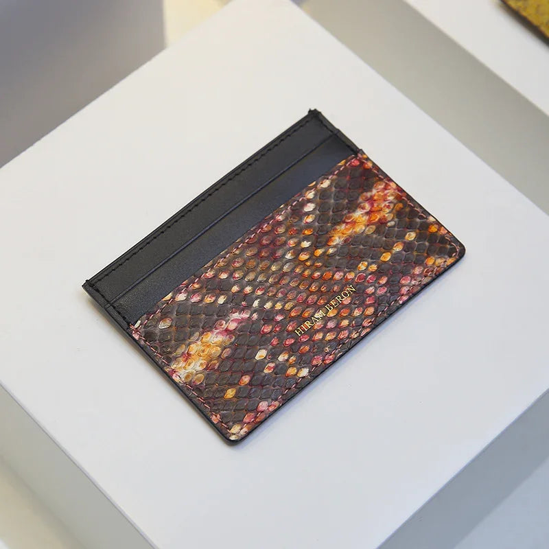 Multicolored snake skin patterned cardholder on a white surface