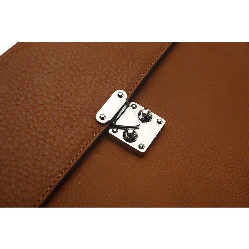 Close-up of a brown leather bag with a silver metal clasp on a white background
