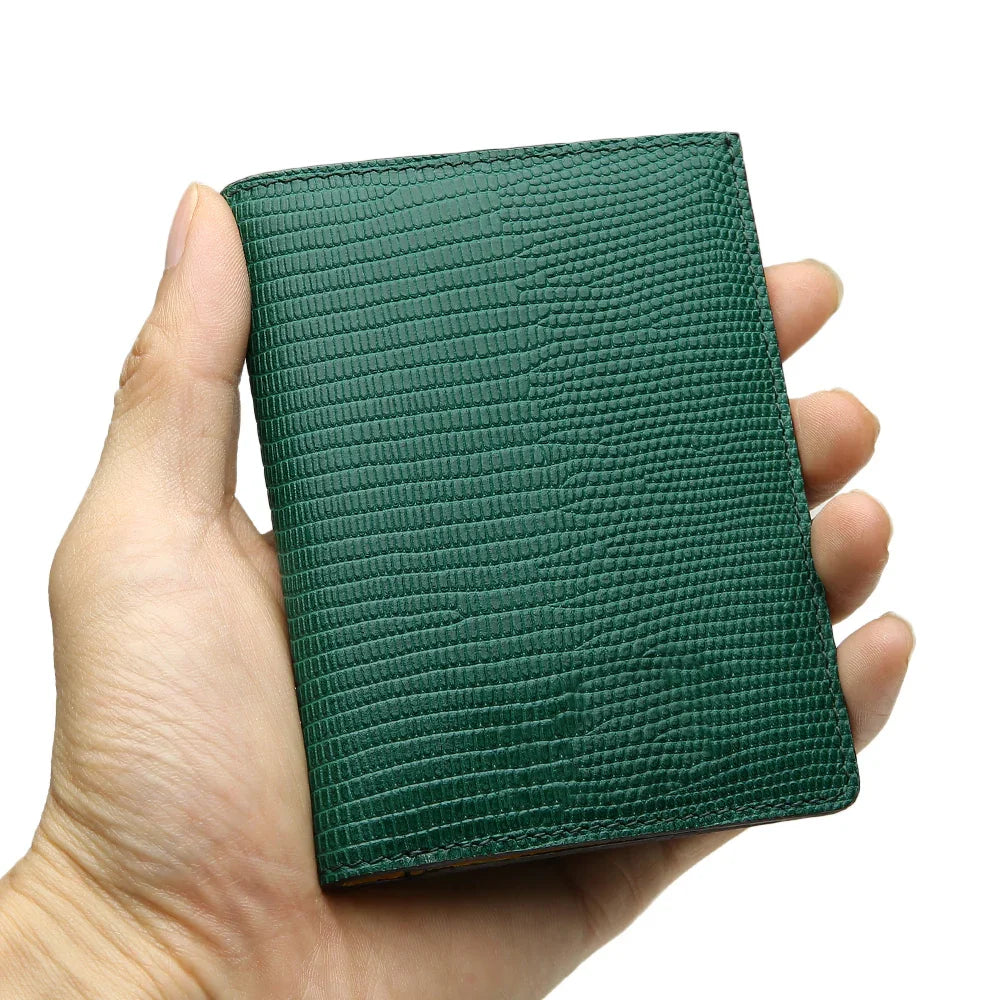 Hand holding a green lizard pattern slim wallet against a white background