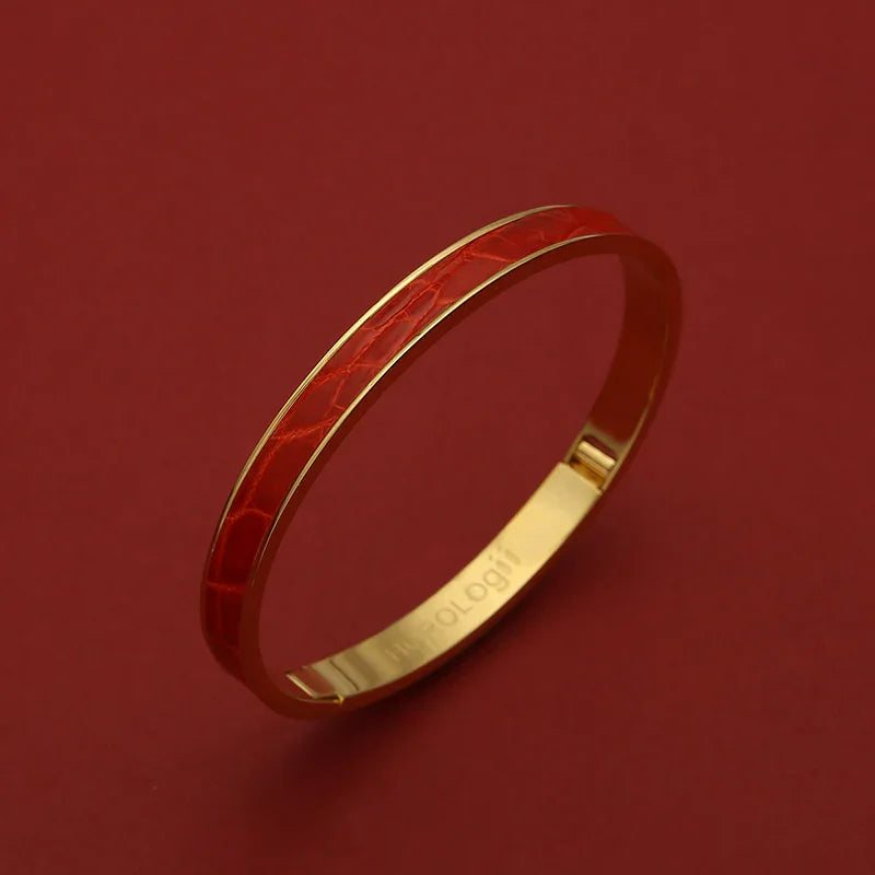 Luxury gold bangle with red crocodile texture, elegant women's jewelry on deep red background