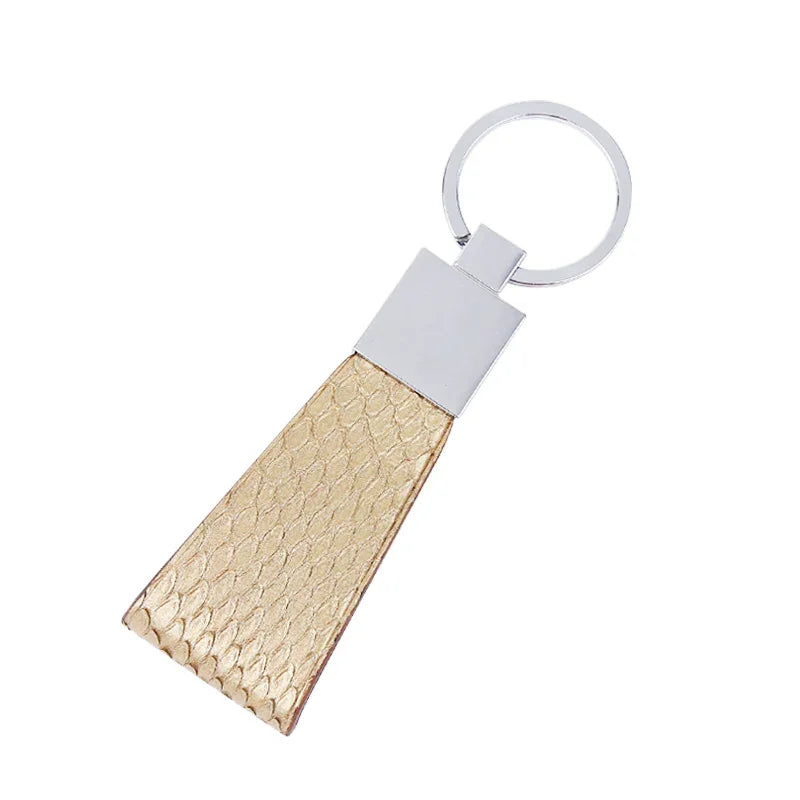 Gold snake skin keychain with white accent on a white background