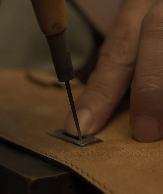 Artisan at Hiram Beron boutique factory performing precision engineering on luxury leather. Professional OEM partner with 14 years of manufacturing mastery for global brands