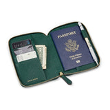 Green pebble leather passport wallet with passport, cards, and money on a white background