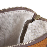 Close-up of a leather bag interior with herringbone lining and gold zipper detail