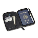 Black pebble leather passport wallet with a passport, money, and cards on a white background
