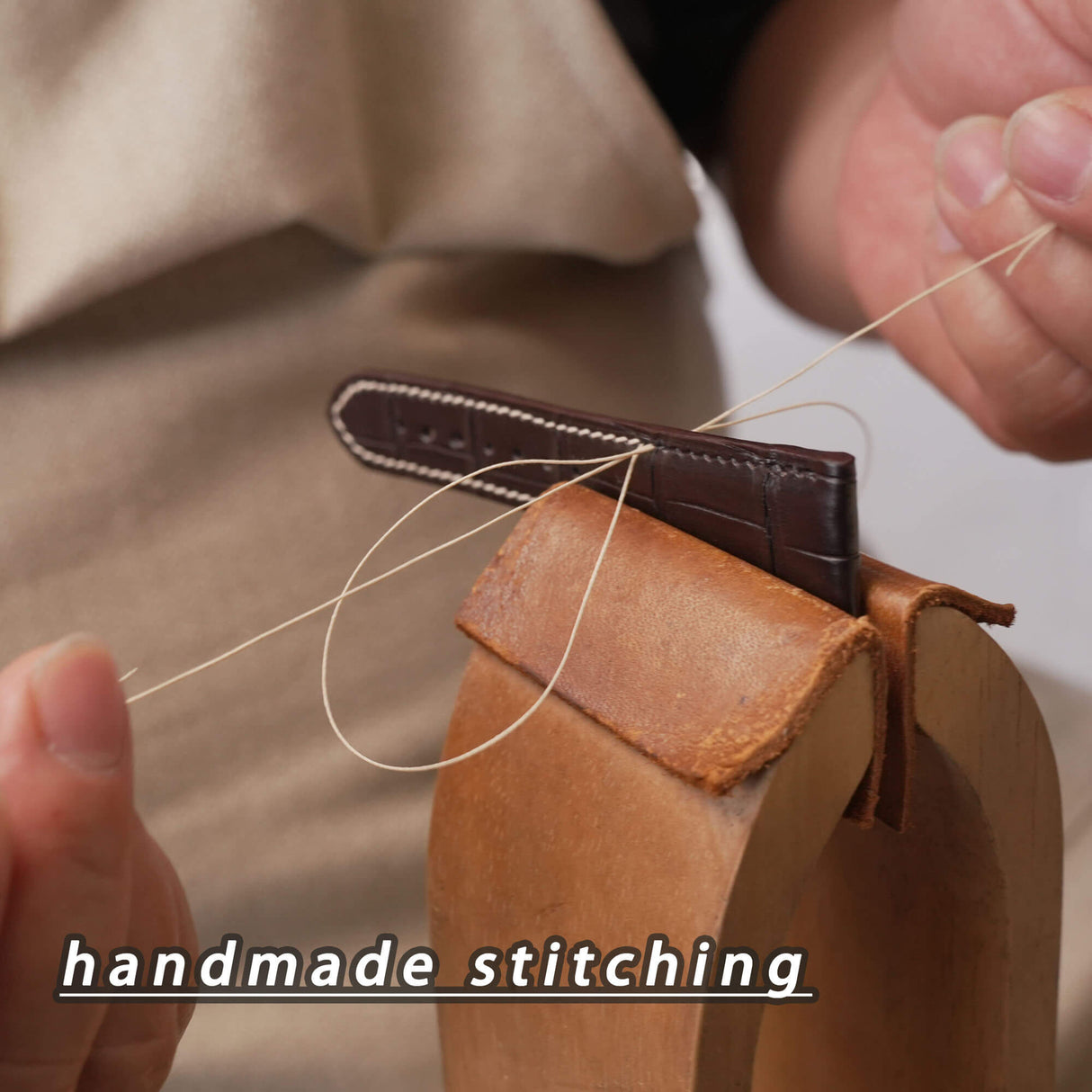 Close-up of fine slant twin-needle hand stitching on a luxury black Hermes-tannery HCP crocodile watch band.
(埋词亮点：slant twin-needle hand stitching, Hermes-tannery HCP crocodile watch band)