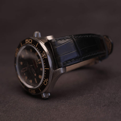 Front view of a premium black French HCP crocodile leather watch strap with elegant bamboo scale pattern and traditional hand-stitched saddle stitching.