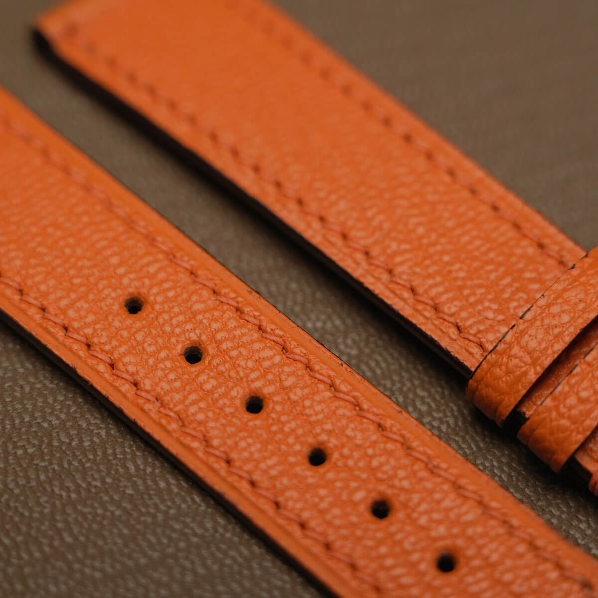 Macro texture of French Alran goatskin grain and hand-finished sealed edge paint on watch strap