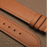 Macro detail of precision linear machine stitching and sealed edge finish on light brown calfskin watch strap