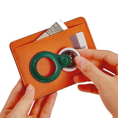 Orange leather wallet with green ring holder, holding cash and cards, ideal for minimalist everyday carry.