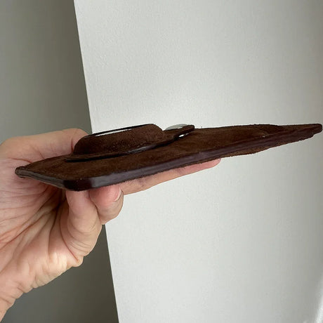 Hand holding a brown leather wallet against a white background