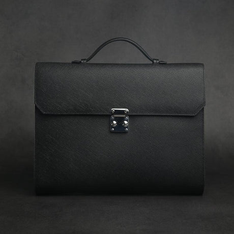 Black leather folio briefcases with a silver clasp on a dark background
