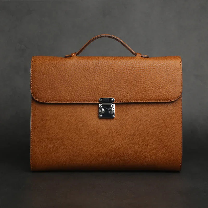 Brown leather tablet briefcases with a silver clasp on a dark background