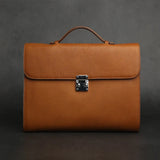 Brown leather tablet briefcases with a silver clasp on a dark background