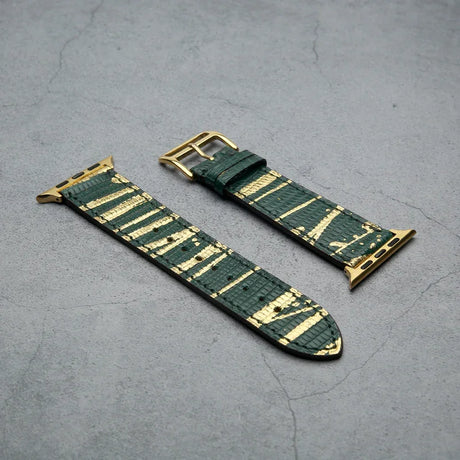 Green and gold lizard skin watch strap on a gray surface