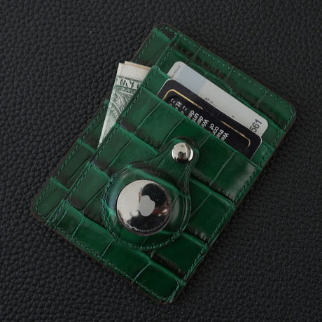 Green card wallet embossed crocodile pattern and a button on a dark textured background