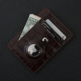 Brown crocodile pattern leather card holder with money and cards on a dark textured surface