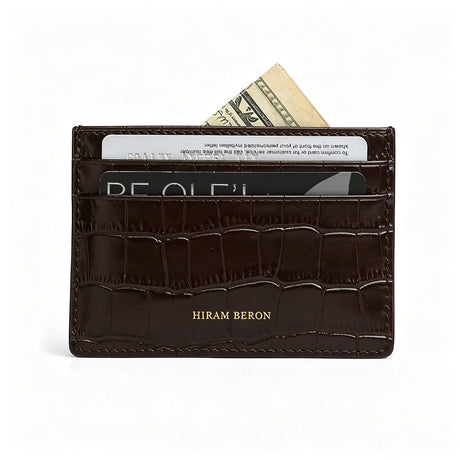 Brown aligator patterned wallet with cards and money on a white background