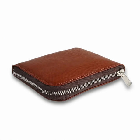Brown vegetable tanned leather coin wallet with a zipper on a white background