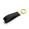 Black python skin key fob with gold accent on a white background