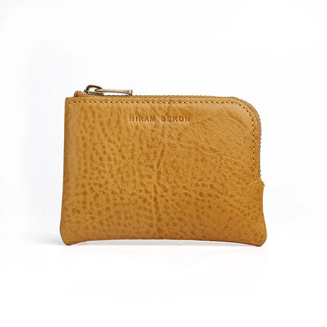 yellow leather coin pouch with 'Hiram Beron' branding on a white background