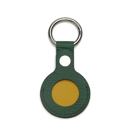 Green leather keychain with yellow accent circle and silver ring, luxury accessory