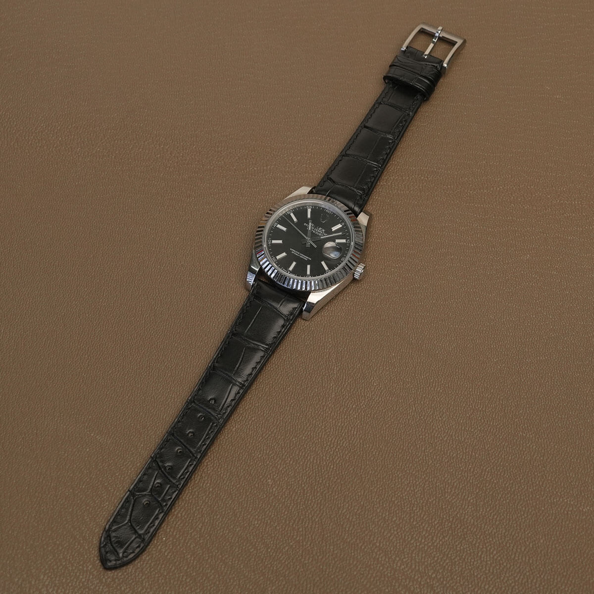 Hand saddle-stitched black HCP alligator leather watch band fitted on luxury fluted bezel watch