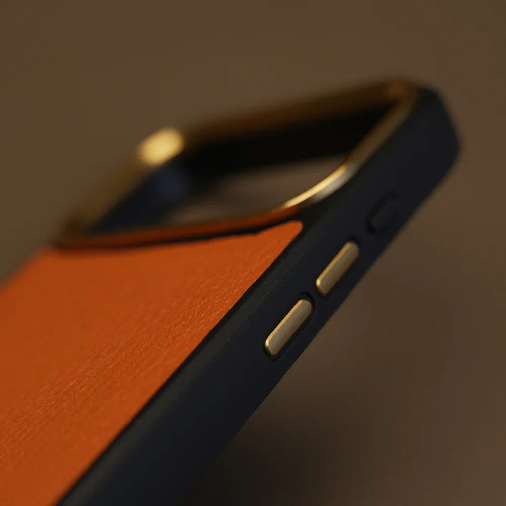 Close-up of a orange phone case with leather texture and metallic accents on a dark background