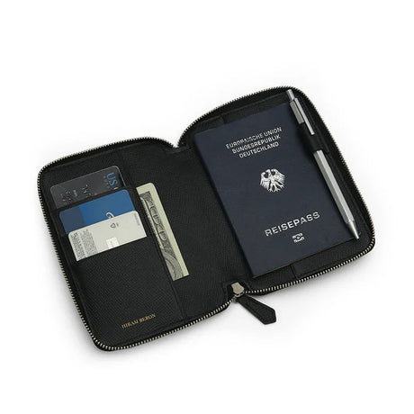 Black leather passport wallet with a passport, card, and money on a white background