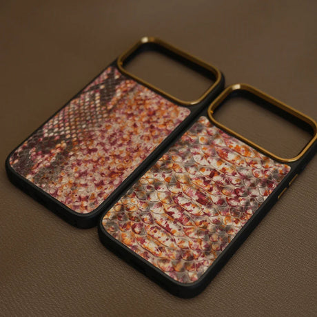 Two phone cases with genuine python on a brown surface