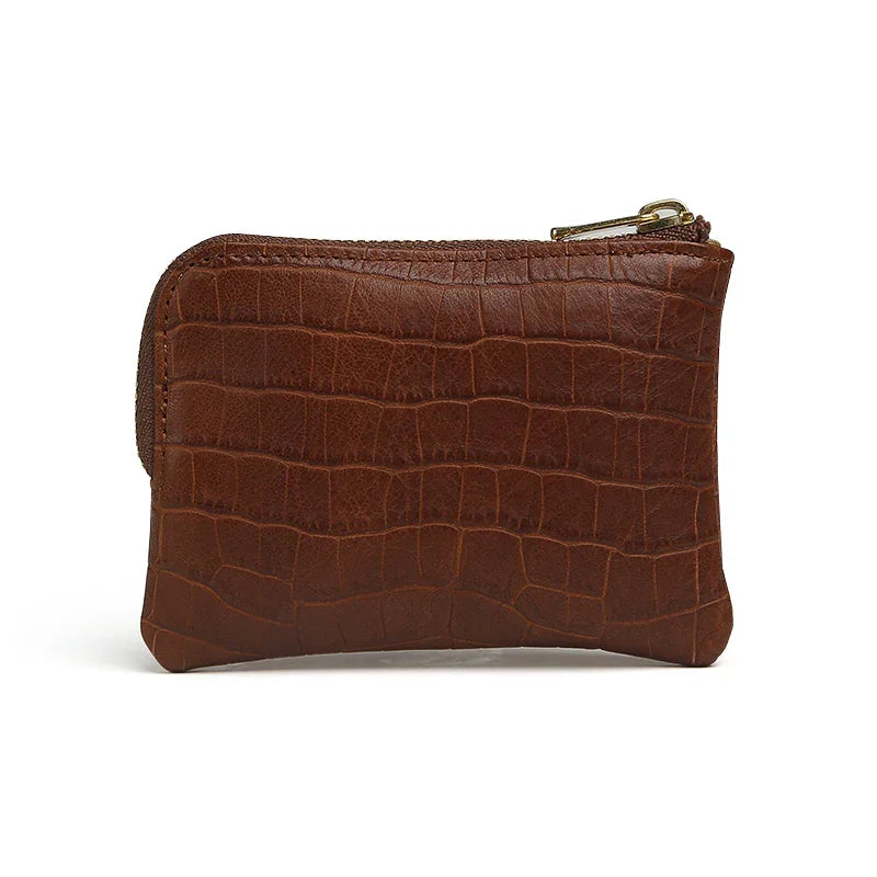 Brown leather coin pouch with crocodile texture on a white background