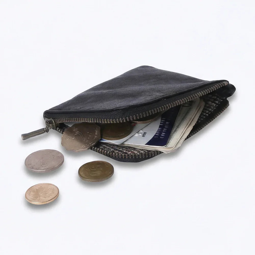 Open black coin pouch wallet with coins and cards on a white background