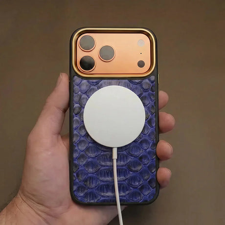 iPhone 17 pro case with snake skin and white magsafe charging and held by a hand against a brown background